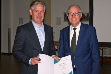 Der Vorsitzende des Kreisverbandes Paderborn im Volksbund Manfred Müller überreicht die goldene Ehrennadel des Volksbundes Deutsche Kriegsgräberfürsorge e.V. an Bürgermeister Michael Berens